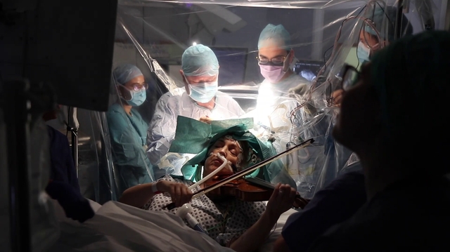 Une patiente joue du violon pendant son opération du cerveau