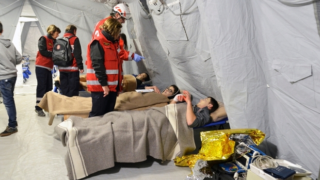 Des volontaires de la Croix Rouge viennent en aide aux réfugiés ukrainiens à la frontière polonaise