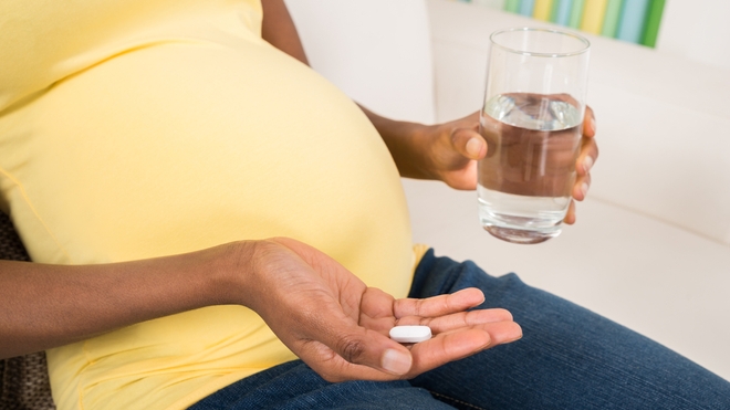 Une femme enceinte qui prend un médicament