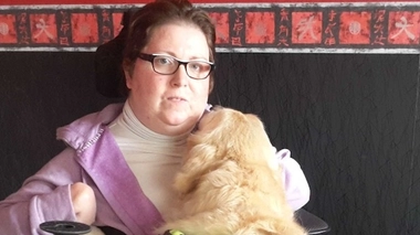 Laurence Lemaître sur son fauteuil roulant, accompagnée de son chien d'assistance