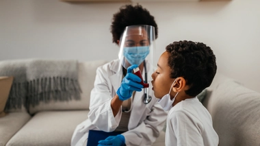 Une médecin aide un petit garçon à utiliser son inhalateur contre l'asthme (photo d'illustration)