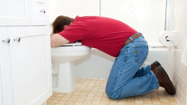 Un homme qui vomit dans ses toilettes (photo d'illustration)