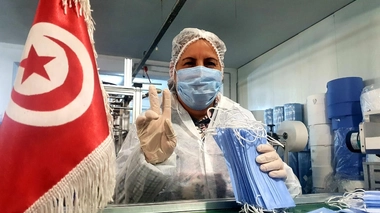 Une ouvrière qui est heureuse de fabriquer des masques pour les hôpitaux de son pays