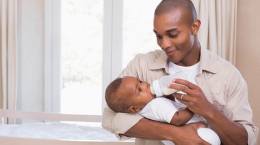 Voici un papa camerounais en train de donner le biberon à son bébé