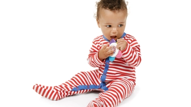 Bébé masse sa gencive avec son anneau de dentition