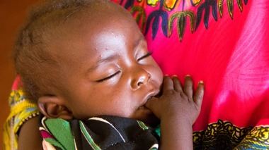 Un bébé ougandais qui dort dans les bras de sa maman 