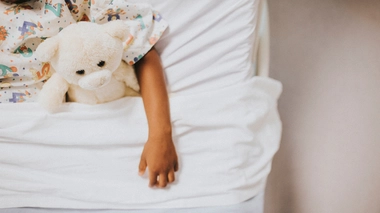 Un enfant qui dort dans un lit d'hôpital