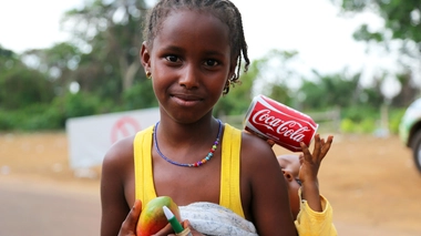 Une fillette à qui l'on donne une canette de Coca-Cola.