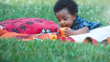 Un enfant qui veut croquer une pomme