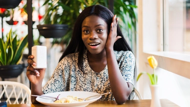 Une femme qui sale son plat au restaurant