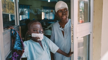 Umar, un patient de 8 ans et Adamu,15 ans, se tiennent à l'entrée du service post-opératoire de l'hôpital Sokoto Noma, au Nigéria