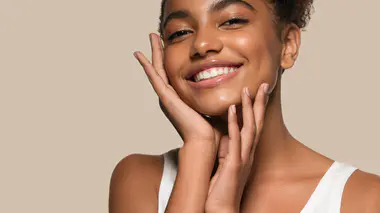 Une femme qui s'applique un produit éclaircissant sur le visage 