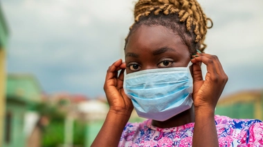 Une femme enfilant un masque chirurgical