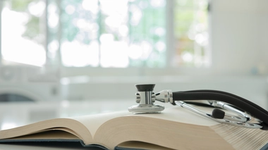 Un stéthoscope posé sur un livre de médecine