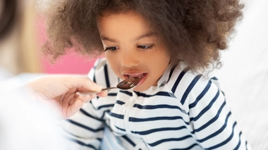 Un enfant qui consomme du sirop contre la toux
