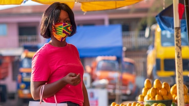 Une femme qui porte un masque dans un marché 